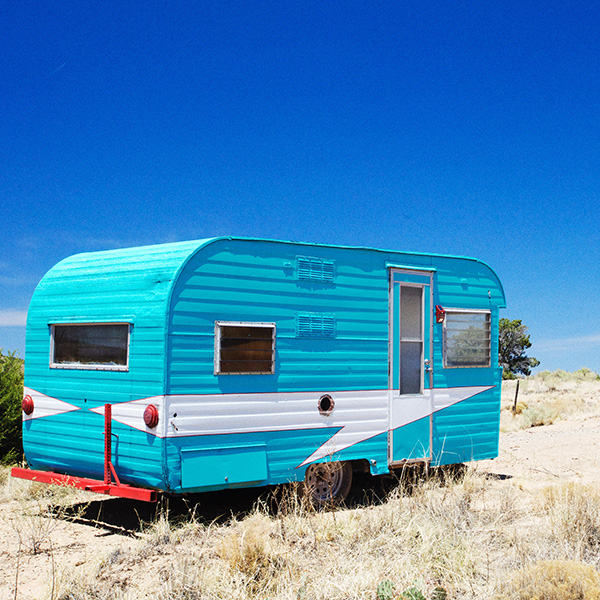 Blue vintage camper in New Mexico field